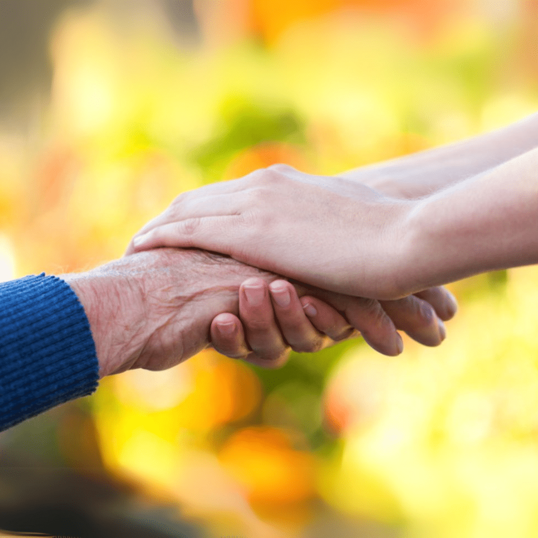 Adult hand holding elder adult hand in a helping way